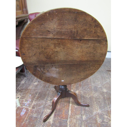 2655 - A Georgian oak snap top table the circular top 80 cm in diameter, raised on a turned pillar and shap... 