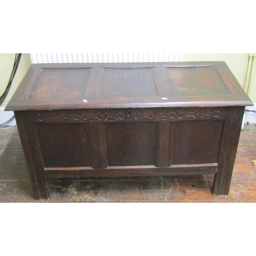 2662 - An 18th century oak panelled coffer with rising lid, the front elevation with repeating geometric fr... 