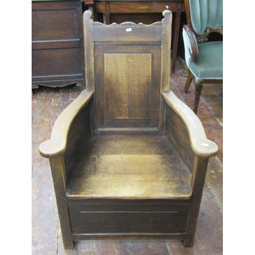 2664 - An 18th century oak enclosed chair with rectangular panelled back beneath shaped cresting rail, with... 