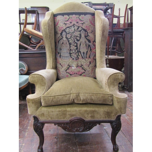 2676 - A substantial Georgian style wing chair with scrolled arms raised on a carved frame, cabriole forele... 