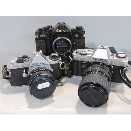 565 - Box of manual 35mm SLR cameras to include Minolta, Pentax and Canon, most with prime and zoom lenses