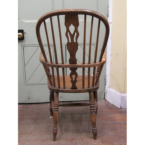 2649 - A Georgian ashwood Windsor elbow chair with shaped and pierced splat, dished seat on turned supports... 