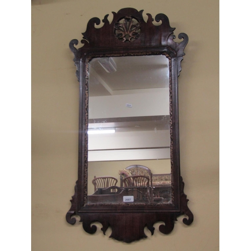 2687 - A Georgian mahogany wall mirror with shaped and fretted framework enclosing a circular carved and gi... 