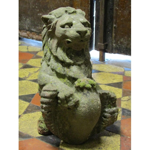 2082 - A small antique weathered carved sandstone lion finial clutching a shield, 32 cm  in height