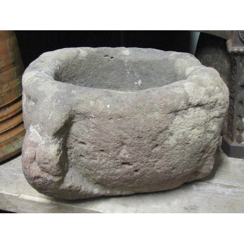 2082A - An early carved natural stone mortar or quern 30cm in diameter approximately