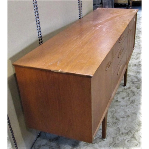 2295 - A mid 20th century teak sideboard fitted with a tower of three central drawers flanked by cupboards ... 