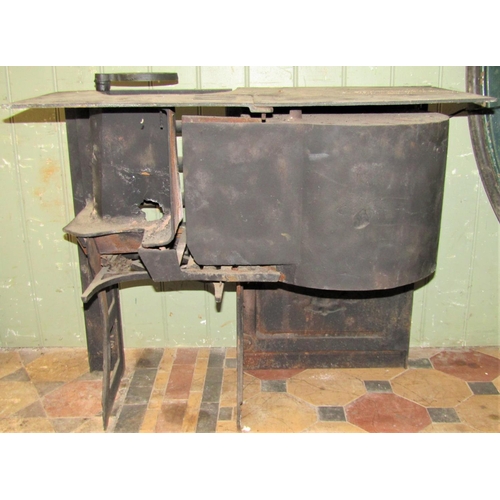 2103 - A small 19th century cast iron range partially enclosed by a single oven door with decorative expose... 