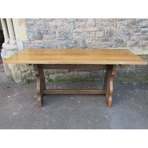 2235 - A reproduction oak refectory table, the rectangular top raised on a pair of shaped slab end supports... 