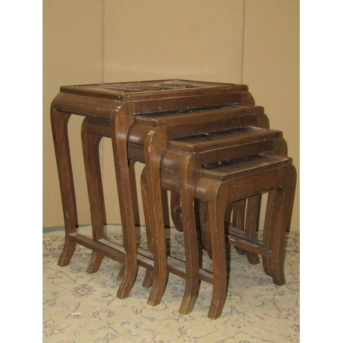 2237 - An eastern quartetto nest of graduated occasional tables with rectangular tops, carved in reserve, u... 