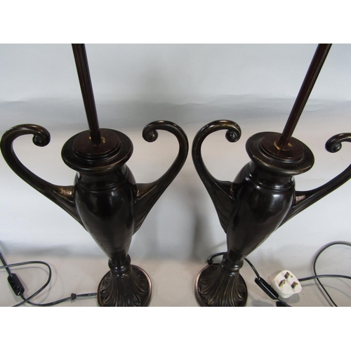 1601 - A pair of lacquered bronzed twin handled baluster vase lamps, upon darted leaf plateau bases, 60cm h... 