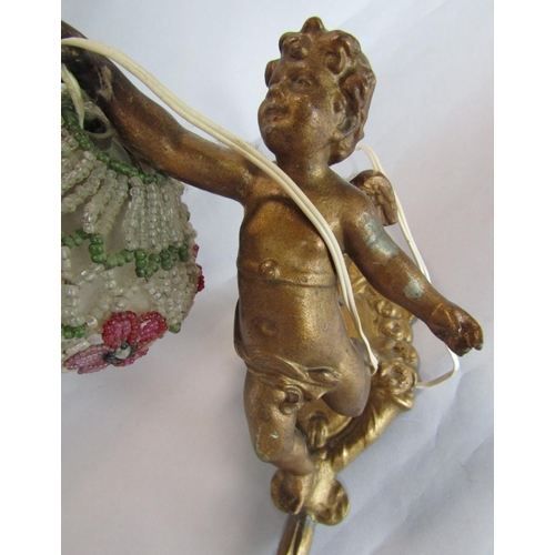 1603 - Cast gilt metal figural lamp in the form of a cherub holding a beaded shade decorated with flowers, ... 