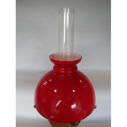 1604 - Aladdin brass oil lamp with red shade and flue, 60cm high total