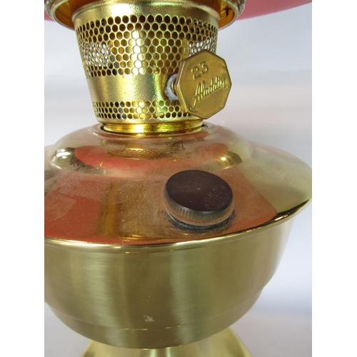 1604 - Aladdin brass oil lamp with red shade and flue, 60cm high total