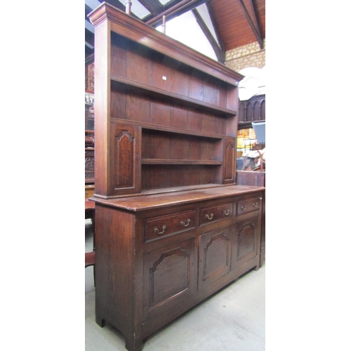 2347 - A Georgian revival oak dresser, the base enclosed by three fielded arched panelled doors and three f... 