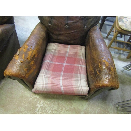 2325 - A pair of 1920/30's brown leather upholstered easy chairs with rolled arms,  button backs, loose sea... 