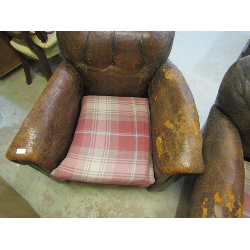 2325 - A pair of 1920/30's brown leather upholstered easy chairs with rolled arms,  button backs, loose sea... 