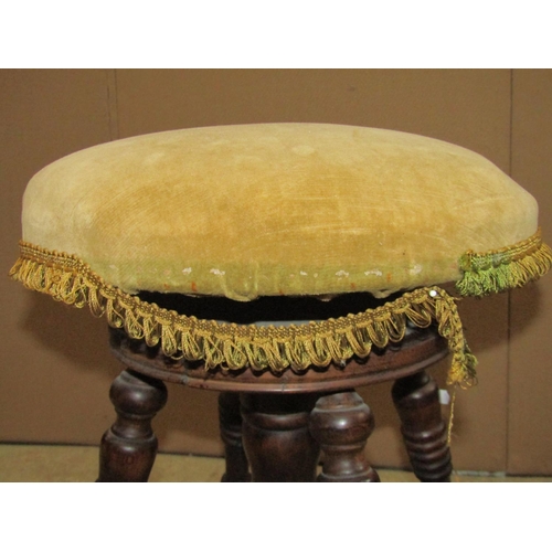 2352 - An Edwardian stained beechwood piano/music stool with circular upholstered revolving adjustable seat... 