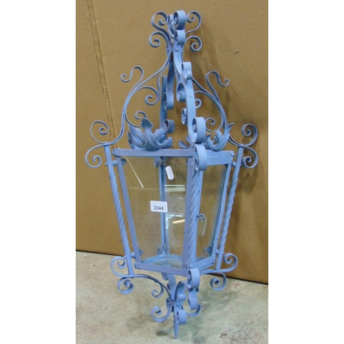 2424 - A hall or porch lantern of square tapered form the decorative painted ironwork frame with scroll det... 