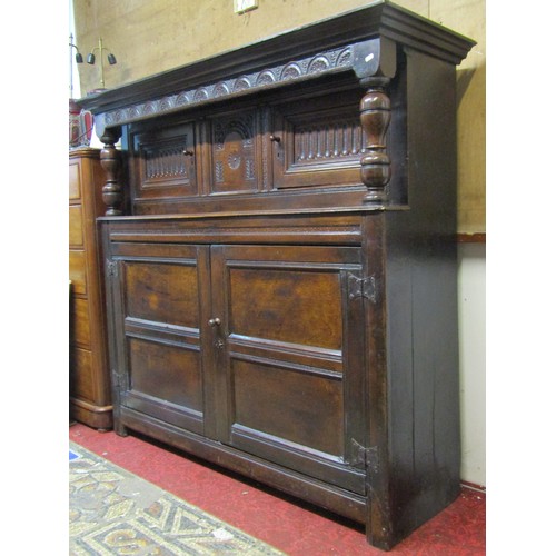 2423 - An 18th century oak court cupboard enclosed by an arrangement of four moulded rectangular panelled d... 