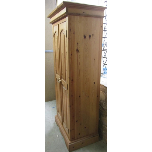 2164 - A contemporary stripped pine wardrobe enclosed by a pair of slender fielded and chamfered panelled d... 