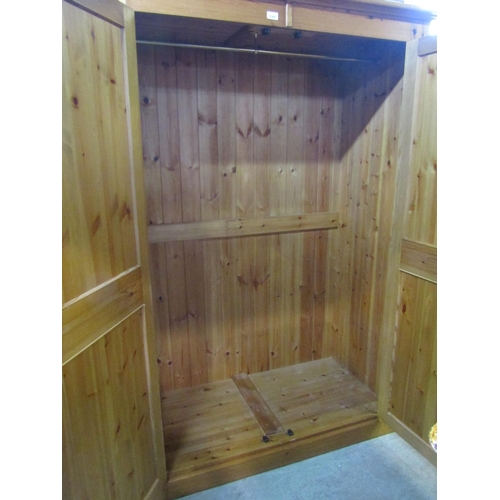 2165 - A contemporary stripped pine wardrobe enclosed by a pair of full length rectangular twin moulded pan... 