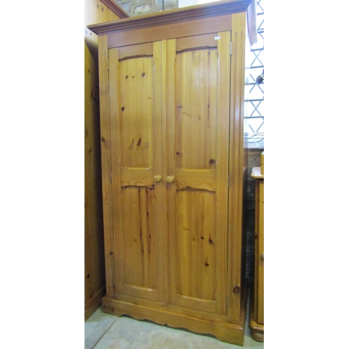 2165 - A contemporary stripped pine wardrobe enclosed by a pair of full length rectangular twin moulded pan... 