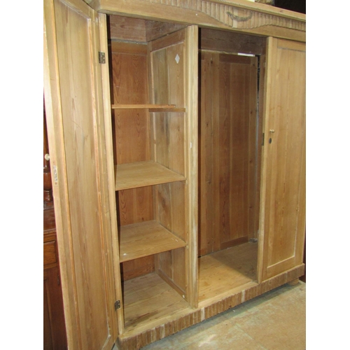 2172 - A continental stripped pine knockdown triple wardrobe, originally enclosed by three full length rect... 