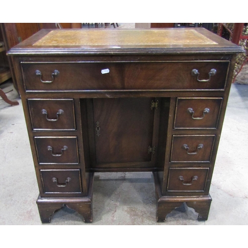 2174 - A reproduction Georgian style mahogany kneehole desk with inset leather panelled top over an arrange... 