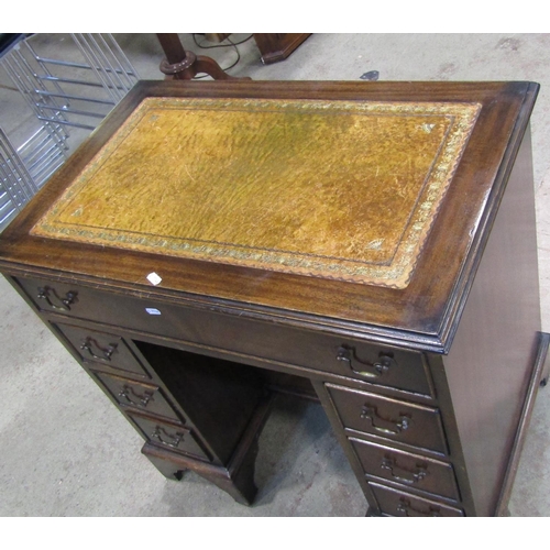 2174 - A reproduction Georgian style mahogany kneehole desk with inset leather panelled top over an arrange... 