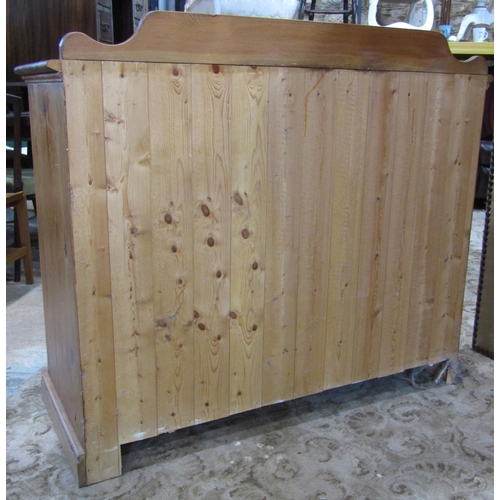 2189 - A stripped pine side cupboard enclosed by a pair of rectangular panelled doors, set on a shallow mou... 