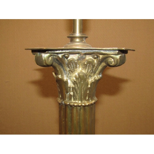 2197 - A cast brass standard lamp in the form of a Corinthian column, with square stepped base and lion's p... 