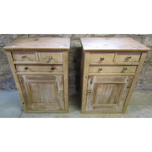 2201 - A pair of low stripped pine side cupboards, each enclosed by a square moulded panelled door beneath ... 