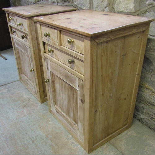 2201 - A pair of low stripped pine side cupboards, each enclosed by a square moulded panelled door beneath ... 