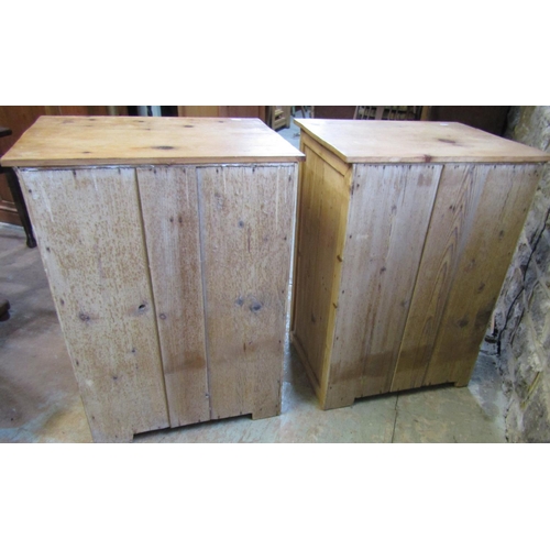 2201 - A pair of low stripped pine side cupboards, each enclosed by a square moulded panelled door beneath ... 