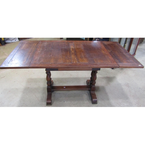 2221 - An oak drawleaf dining table of rectangular form, raised on turned column supports and sledge feet, ... 