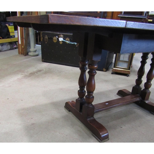 2221 - An oak drawleaf dining table of rectangular form, raised on turned column supports and sledge feet, ... 