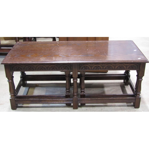 2228 - A Jaycee dark stained oak nest of occasional tables, with carved frieze, raised on turned supports u... 