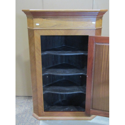 2245 - A Georgian style pale walnut and rosewood veneered hanging corner cupboard, enclosed by a rectangula... 