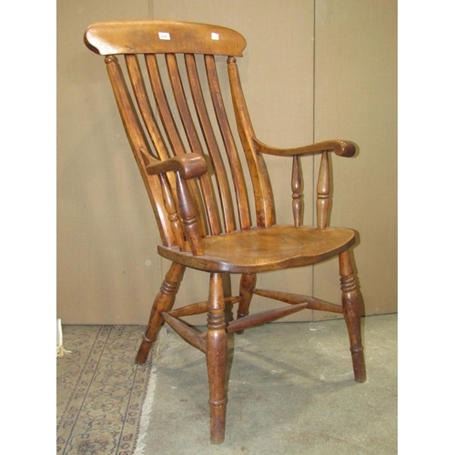 2255 - A Windsor stained elm and beechwood lathe back armchair with saddle shaped seat raised on ring turne... 