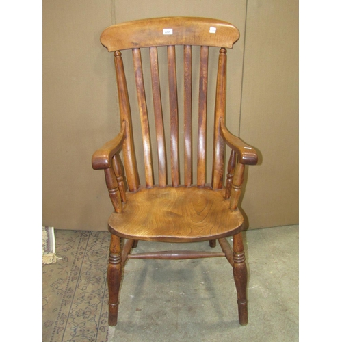 2255 - A Windsor stained elm and beechwood lathe back armchair with saddle shaped seat raised on ring turne... 