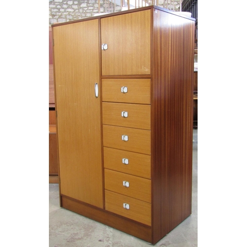 2263 - A small teak combination wardrobe enclosed by an arrangement of two doors and tower of six drawers, ... 