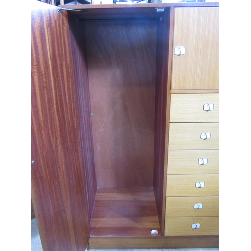 2263 - A small teak combination wardrobe enclosed by an arrangement of two doors and tower of six drawers, ... 