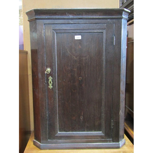 2264 - A Georgian oak hanging corner cupboard enclosed by a rectangular moulded panelled door with two fixe... 