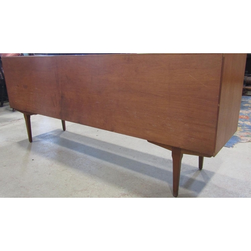 2278 - A Nathan teak long and low sideboard partially enclosed by a pair of sliding doors and three long dr... 