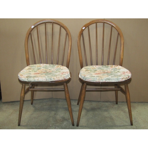 2279 - A pair of Ercol stained elm and beechwood hoop and stick back dining  chairs raised on simple turned... 