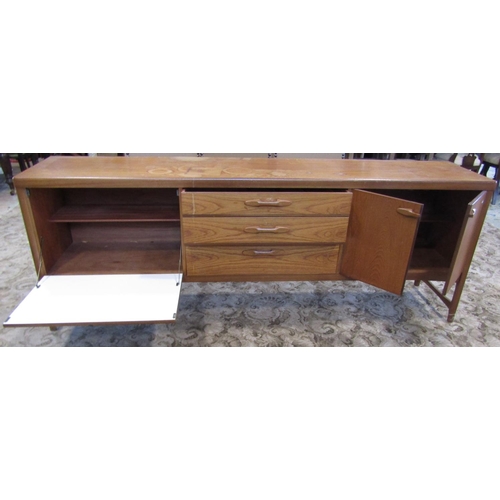 2297 - A long and low retro teak sideboard enclosed by an arrangement of three doors one with fall front fl... 