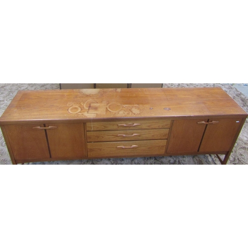 2297 - A long and low retro teak sideboard enclosed by an arrangement of three doors one with fall front fl... 