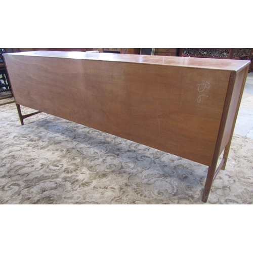 2297 - A long and low retro teak sideboard enclosed by an arrangement of three doors one with fall front fl... 