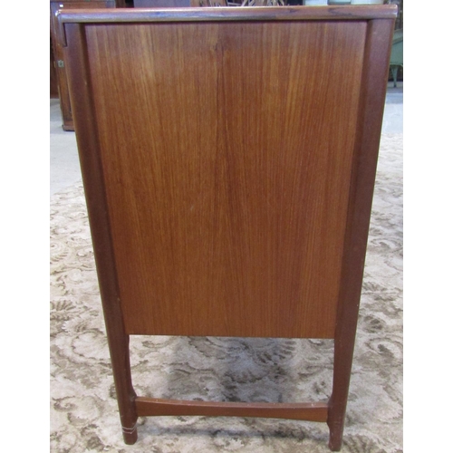 2297 - A long and low retro teak sideboard enclosed by an arrangement of three doors one with fall front fl... 