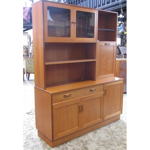 2304 - A G plan teak floorstanding wall unit in two sections enclosed by an arrangement of cupboards and dr... 